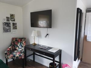 Habitación con escritorio, silla y TV. en Rasta Götene en Götene