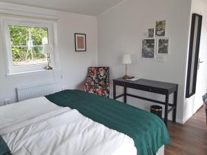 1 dormitorio con cama, escritorio y silla en Rasta Götene en Götene