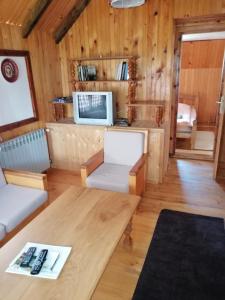 a living room with a table and a couch at Apartment Skulova Vodenica in Mokra Gora