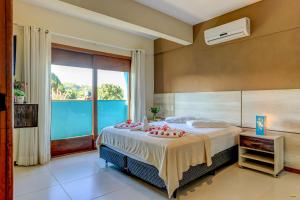 a bedroom with a bed and a large window at i9 Quixaba Flat in Itacaré +56 photos
