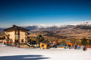 a ski lodge with snow covered mountains in the background at Gite Cal Pai in Eyne