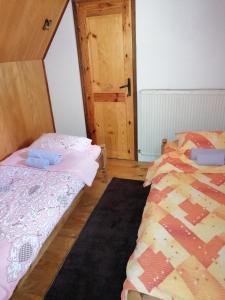 a bedroom with two beds and a door at Apartment Skulova Vodenica in Mokra Gora