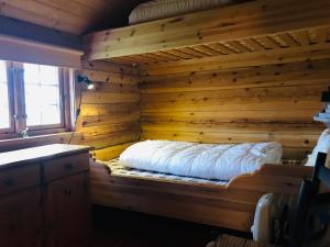 Midnight Sun Lodge Lofoten في Bøstad: غرفة مع سرير في جدار خشبي
