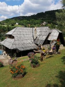 an old house with flowers in front of it at Apartment Skulova Vodenica in Mokra Gora