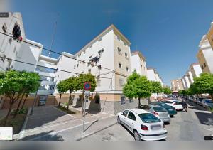 um carro branco está estacionado em frente a um edifício em Acogedor apartamento en el barrio del Parlamento de Andalucía (Sevilla) em Sevilha