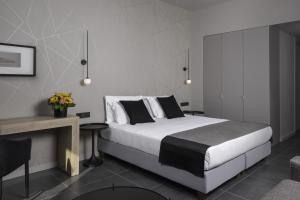 a bedroom with a bed and a table and a desk at Azur Suites in Athens