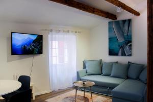 sala de estar con sofá azul y TV en Sea Apartment Carera, en Rovinj