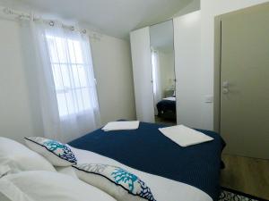 Un dormitorio con una cama azul y blanca y un espejo en Sea Apartment Carera, en Rovinj