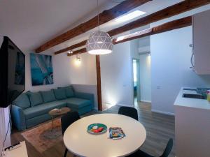 sala de estar con mesa y sofá azul en Sea Apartment Carera, en Rovinj