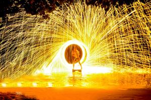 a woman is standing in a fire fountain at Phi Phi Relax Beach Resort in Phi Phi Islands