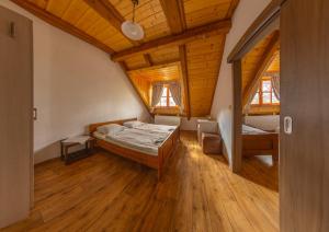 1 dormitorio con 2 camas y techo de madera en Pension & Restaurant U Koňské dráhy Holkov en Velešín