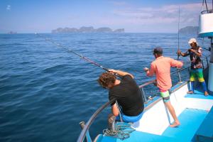 a group of people fishing on a boat in the water at Phi Phi Relax Beach Resort in Phi Phi Islands
