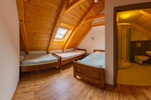 una habitación con 2 camas y un baño en una casa en Pension & Restaurant U Koňské dráhy Holkov en Velešín