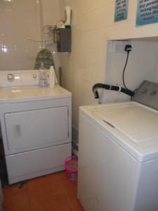 a bathroom with a washing machine and a washer at Sandras Backpackers in Thurso