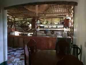 a dining room with a table and a kitchen at Bamboo Nest in Puerto Princesa City