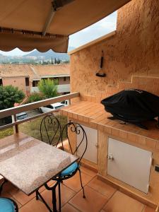 stół i krzesła na balkonie ze stołem w obiekcie Appt T2 refait à neuf - vue mer dans résidence avec piscine w mieście Mandelieu-la-Napoule