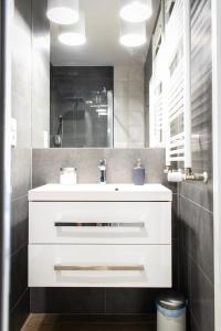 a bathroom with a white sink and a mirror at Dream LUX Apartments in Kraków