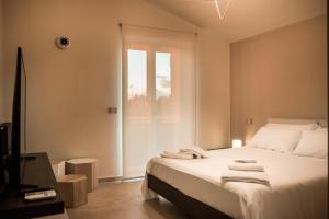una camera da letto con un letto con lenzuola bianche e una finestra di Sea Front House - Tono Milazzo a Milazzo