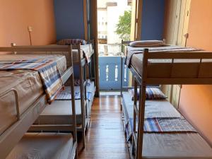 a room with several bunk beds in a room with a window at Massape Rio Hostel in Rio de Janeiro