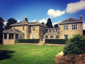 a large brick house with a lawn in front of it at Walltree House in Brackley