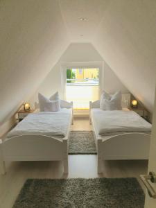1 dormitorio en el ático con 2 camas y ventana en Ferienhaus Pearl en Ueckeritz