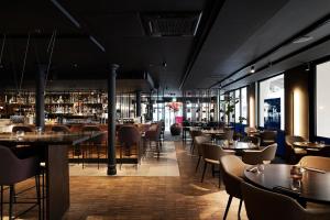 a restaurant with tables and chairs and a bar at Elite Hotel Esplanade in Malmö