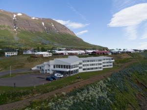 eine Luftansicht eines weißen Gebäudes vor einem Berg in der Unterkunft The Cliff Hotel in Neskaupstaður