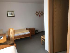 ein kleines Zimmer mit einem Bett, einem Tisch und einem Stuhl in der Unterkunft Stadtsee-Pension Templin in Templin