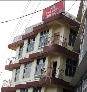 a building with a sign for a guest house at Shillong Guest House in Shillong