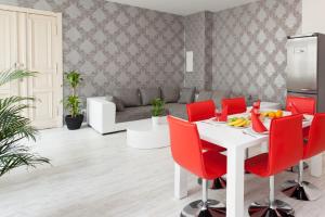 une salle à manger avec une table blanche et des chaises rouges dans l'établissement The Cloud, à Berlin 11 autres photos