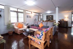 a living room with a couch and a table at Dunah's Garden Home in Bangkok
