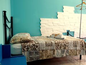 a bed in a room with a blue wall at Angulum in Citta' Sant'Angelo