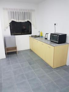 a kitchen with a counter top and a microwave at Sembulan @ Ning Guesthouse 宁舒民宿 in Kota Kinabalu