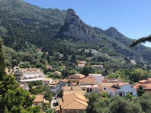 une ville sur une colline avec une montagne en arrière-plan dans l'établissement Sebastian's - Agios Gordios Beach, à Agios Gordios