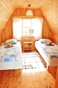 1 dormitorio con 2 camas en una cabaña de madera en Kuuli Puhkemajad, en Tagaranna