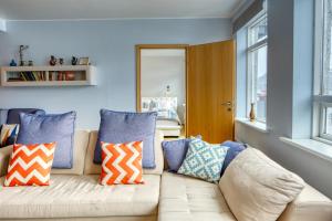 a living room with a couch with pillows on it at Hildibrand Apartment Hotel in Neskaupstaður