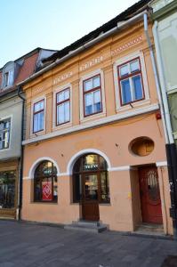 un edificio naranja en una calle con ventanas en KAYA STUDIO en Sibiu