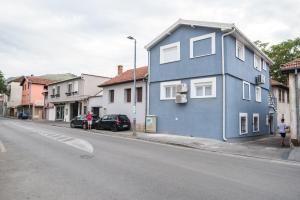 une maison bleue sur le côté d'une rue dans l'établissement Love Apartments, à Mostar