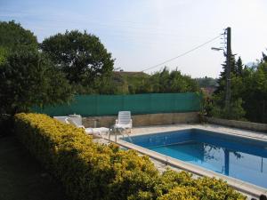 een zwembad met 2 stoelen en een hek bij La Frandomière in Saint-Martin-de-Londres