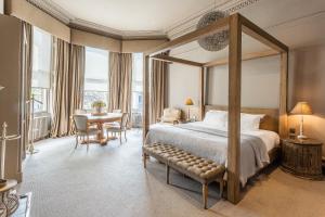 una camera con letto a baldacchino e tavolo e sedie di Murrayfield Hotel a Edimburgo