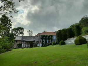 ein großes Haus auf einem grünen Hügel mit Hof in der Unterkunft Le Bocage Fleuri in Mons