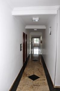a hallway with white walls and a tile floor at Hotel Buriti Shop in Goiânia