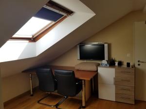 a room with a desk and a tv in a attic at Studio direkt am Bodensee in Thal