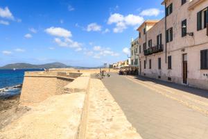 una strada accanto a una spiaggia con edifici e l'oceano di Casa Jaume ad Alghero