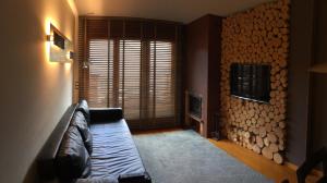 a living room with a couch and a log wall at Bosquet 1 in Canillo