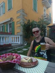 een man aan een tafel met een glas bier bij Agritur Tenno Cantina Bio Natura in Tenno