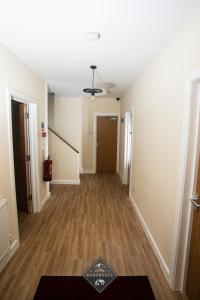 a hallway of an apartment with wood floors and a ceiling at Celtic House in Merthyr Tydfil