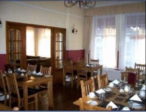 Kingsley Hotel في بورنموث: غرفة طعام مع طاولات وكراسي ونوافذ
