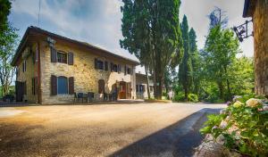 a large stone house with trees in front of it at Hotel Parco Fola in Albinea