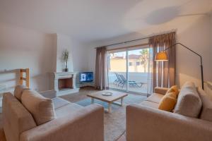 a living room with two couches and a fireplace at Acolhedora Vivenda Geminada Praia D'el Rey in Casal da Lagoa Seca